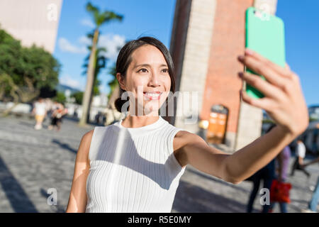 Jeune femme en tenant avec selfies téléphone mobile à Hong Kong Banque D'Images