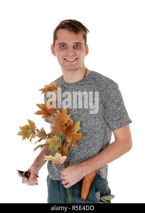 A smiling young debout avec une branche de feuilles d'automne dans sa main et un couteau dans l'autre, isolés pour fond blanc Banque D'Images