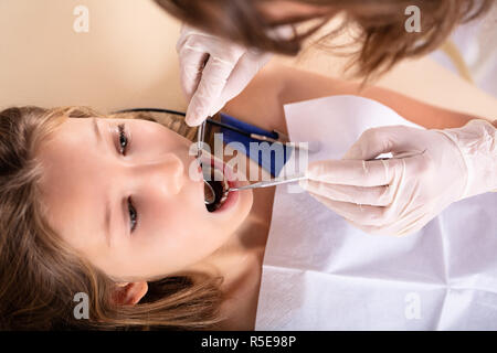 Close-up of Girl Contrôlé par dentiste avec miroir dentaire et Scaler Banque D'Images