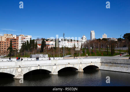 Pont Puente del Rey au-dessus de la rivière Manzanares, les bâtiments Jardines del Virgen del Puerto près de principe Pio et Plaza España en arrière-plan, Madrid, Espagne Banque D'Images