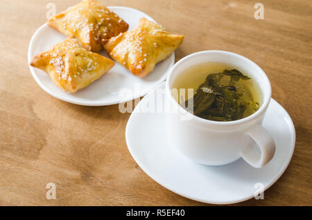 Du thé vert et de pâtés sur table en bois rustique. Concept petit-déjeuner. Banque D'Images