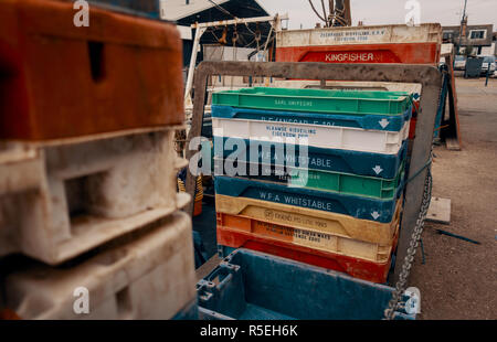 Fruits de mer en plastique de marque stand caisses empilées sur le port prêt à être rempli avec les prises dans Hastings, Angleterre, Royaume-Uni. Banque D'Images