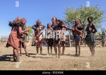 Groupe des femmes Himba avec des vêtements traditionnels de la danse en cercle, certains d'entre eux tout en portant leur bébé sur le dos. Banque D'Images