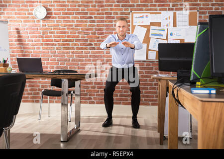 Businessman Doing Exercise in Office Banque D'Images