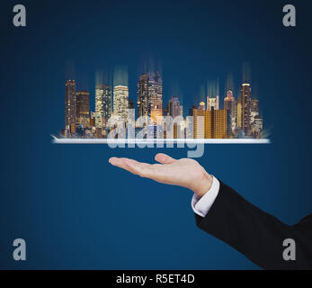 Businessman hand holding digital tablet avec les bâtiments modernes hologramme. Smart city, techniques de construction et l'immobilier Banque D'Images