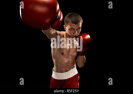 Male boxer boxing avec éclairage edgy spectaculaire dans un studio sombre Banque D'Images