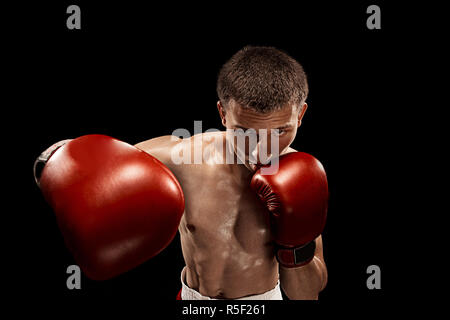 Male boxer boxing avec éclairage edgy spectaculaire dans un studio sombre Banque D'Images