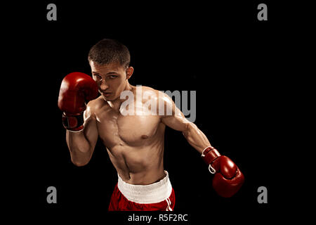 Male boxer boxing avec éclairage edgy spectaculaire dans un studio sombre Banque D'Images