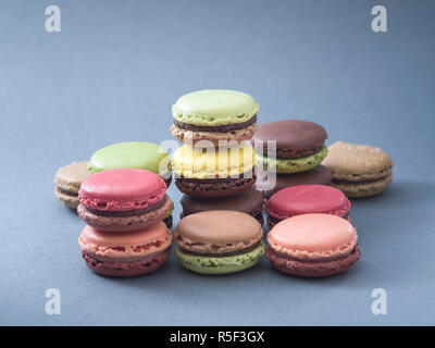 Macaron pâtisserie savoureuse cuisine française et variations de couleurs avec un fond bleu. Banque D'Images