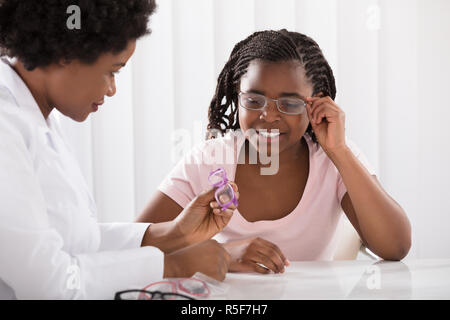 Optométriste aider fille à choisir les lunettes Banque D'Images