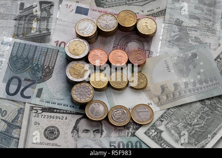 Des piles de pièces en euro sous la forme d'un symbole de l'euro. Arrière-plan de billets. Euro et dollars US monnaie. Selective focus Banque D'Images