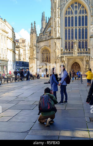 Les visiteurs d'avoir leur photo prise en face de l'abbaye de Bath. Un jour en hiver le centre-ville de Bath, Somerset england UK Banque D'Images