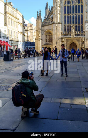 Les visiteurs d'avoir leur photo prise en face de l'abbaye de Bath. Un jour en hiver le centre-ville de Bath, Somerset england UK Banque D'Images