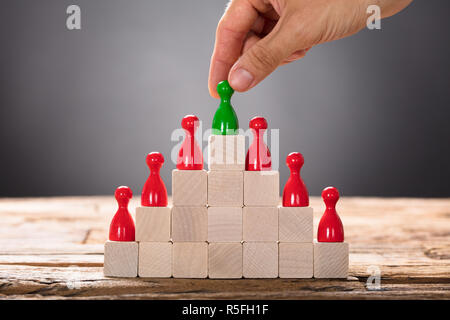 Placer la main pion vert avec d'autres figurines rouge sur les blocs Banque D'Images