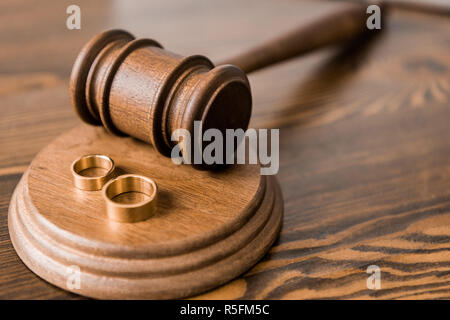 Vue rapprochée d'un marteau en bois et les anneaux de mariage sur la table, le divorce concept Banque D'Images