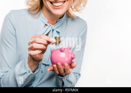 Cropped shot of smiling businesswoman holding piggy bank et coin isolated on white Banque D'Images