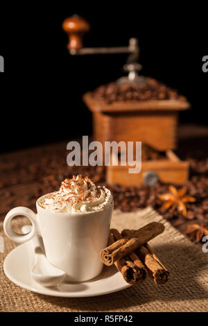 Tasse de café avec de la crème fouettée et rectifieuse de café sur l'arrière-plan Banque D'Images