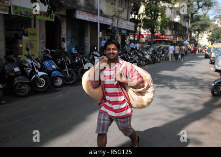 Un jeune homme dans le domaine commercial fort, Mumbai, Inde, transporter des sacs Banque D'Images