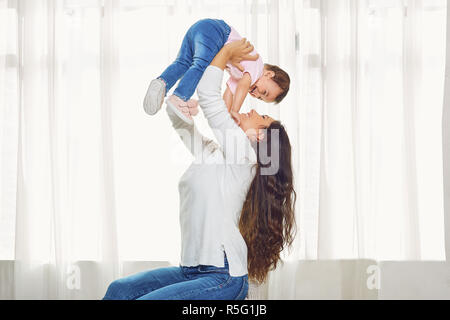 Mère brunette joue avec l'enfant à la maison. Banque D'Images