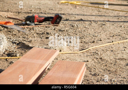 Outils sur le sol devant une pile de planches utilisées dans la rénovation résidentielle Banque D'Images