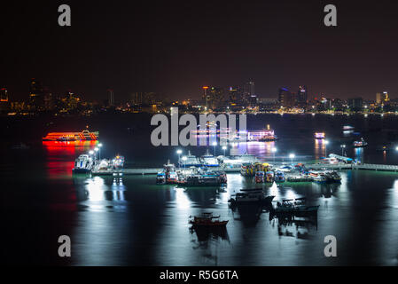 Bateaux et Ferry Pattaya City Marina Bay dans la nuit avec la ville en arrière-plan la Thaïlande Banque D'Images