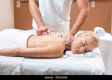 Masseur masculin massage faisant de belle femme aux yeux clos à spa Banque D'Images