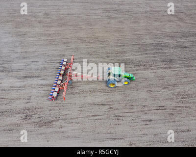 Les semis de maïs. Tracteur avec un semoir sur le terrain. À l'aide d'un semoir pour planter du maïs. Banque D'Images