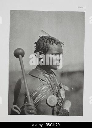 Un dandy Pondo. Ce jeune homme a un knobkerrie dans sa main, quelques peignes métalliques dans ses cheveux, et une cocia-tin hung autour du cou comme ornement, ainsi qu'à deux-verres en cas de tables rondes en bois. Il a formé quelques brins de cheveux de tomber en face de son nez, et a tendu quelques perles sur les cheveux pour l'ornement. Les Kafirs ... Avec une centaine d'illustrations pleine page par l'auteur. Londres : Adam & Charles Black, 1904. Source : 10096.h.20 Figure 11. Auteur : Kidd, Dudley. Banque D'Images