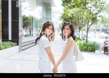 Les amis faire du shopping. Deux jeunes femmes marcher sur shopping mall avec des sacs Banque D'Images