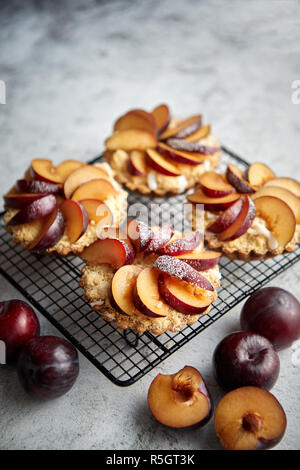 Tartelettes crumble fait maison avec des tranches de prune mis sur la cuisson grill fer Banque D'Images