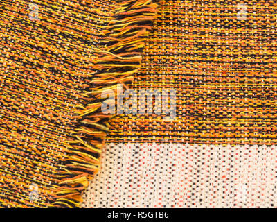 Tissu de coton mélangé d'orange, noir, jaune et blanc, plié avec des franges Banque D'Images