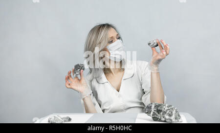 Une femme travailleur de laboratoire examine des pierres pour anilization, le contenu de l'amiante. Banque D'Images