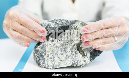 Une fille est technicien de laboratoire pour l'analyse des pierres d'amiante holding. Banque D'Images