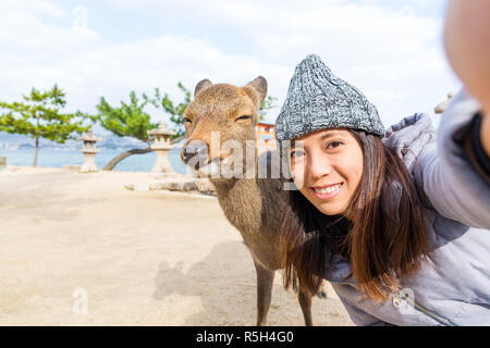 Prendre Femme avec selfies deer dans Itsukushima Banque D'Images