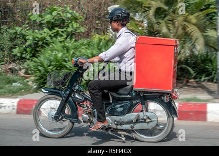 MANDALAY, Myanmar, le 21 mai 2018, la livraison des envois sur moto. Manèges motocycliste avec livraison dans la grande boîte rouge sur rue, la Birmanie. Banque D'Images