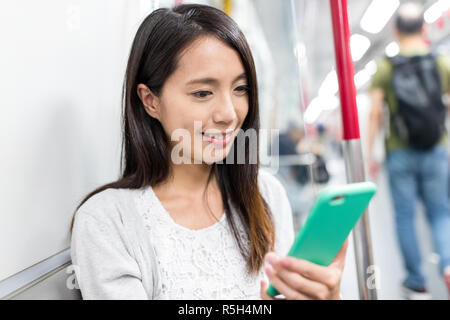 Femme uisng tél. mobile sur train Banque D'Images