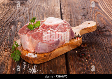 Beefsteak cru sur planche à découper Banque D'Images