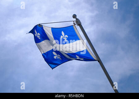 Drapeau du Québec national au Canada voletant dans le vent on blue sky Banque D'Images