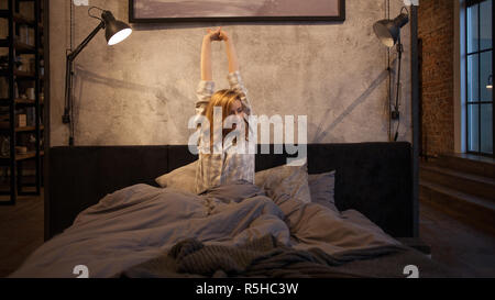 Sleepy girl va au lit le soir. Jeune femme en pyjama, se mit au lit. Banque D'Images