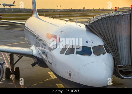 British Airways Airbus A320 jet relié à un pont aérien de passagers à l'aéroport de Prague prêt pour un départ tôt le matin Banque D'Images