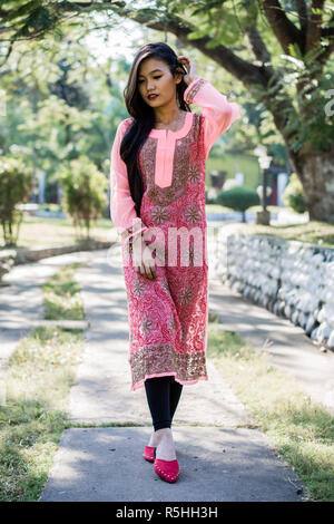 Girl in Chikankari Kurti par Zahba posant pour l'appareil photo dans un parc. Banque D'Images