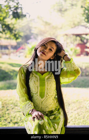 Girl in Chikankari Kurti par Zahba posant pour l'appareil photo dans un parc. Banque D'Images