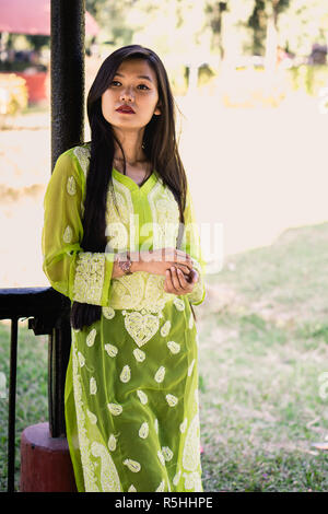 Girl in Chikankari Kurti par Zahba posant pour l'appareil photo dans un parc. Banque D'Images