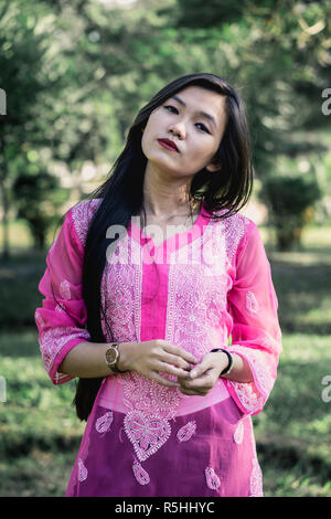 Girl in Chikankari Kurti par Zahba posant pour l'appareil photo dans un parc. Banque D'Images