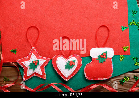 Rustique fait main de décorations de Noël en rouge et feutre vert sur table en bois Banque D'Images