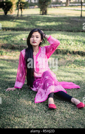 Girl in Chikankari Kurti par Zahba posant pour l'appareil photo dans un parc. Banque D'Images