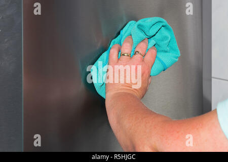 Ménage essuyer la poussière et la saleté avec chiffons bleu. Banque D'Images