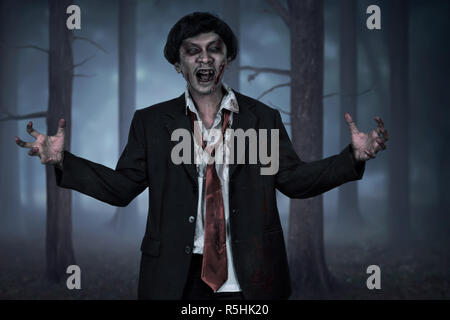 Effrayant zombie asiatique homme portant costume avec main ouverte Banque D'Images