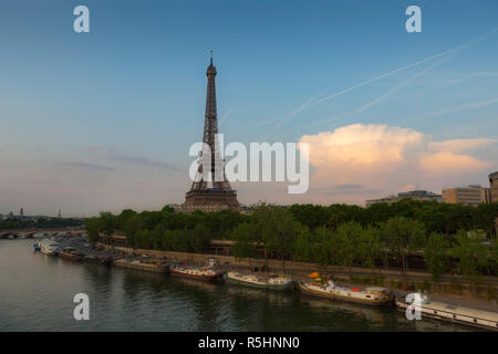 Tour Eiffel, un pylône en treillis en fer forgé sur le Champ de Mars à Paris, France, photographié au coucher du soleil à partir d'un pont sur la Seine, avec blue Banque D'Images