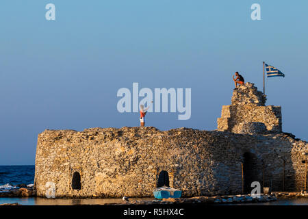 Athènes, Grèce - 30 août 2018 : femme prend des photos de son compagnon avec un bâton selfies et téléphone mobile, staning sur une ancienne ruine, avec vue sur mer i Banque D'Images